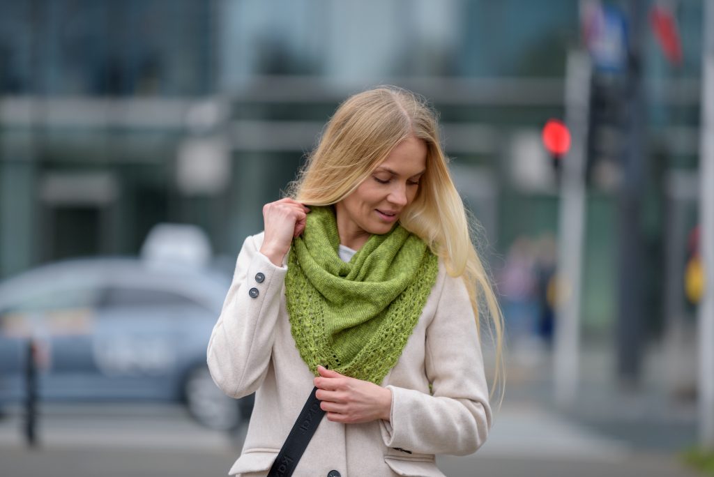 Młoda kobieta otulona zielonym delikatnym szalem z wełny merino