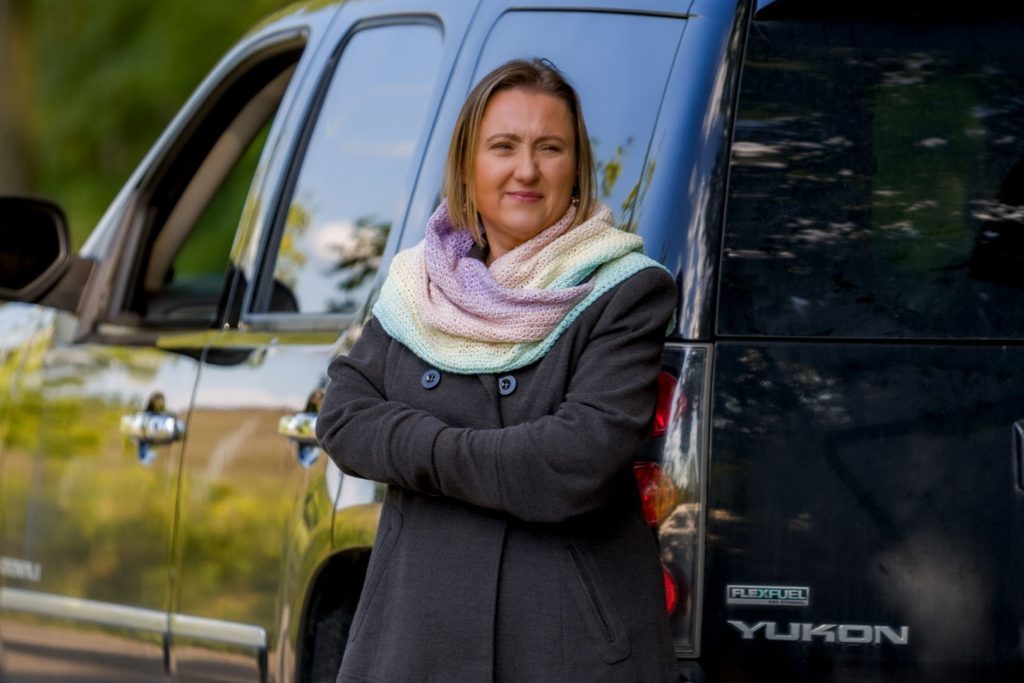 młoda kobieta otulona chustą w kolorach fioletu, żółtego i zeleni